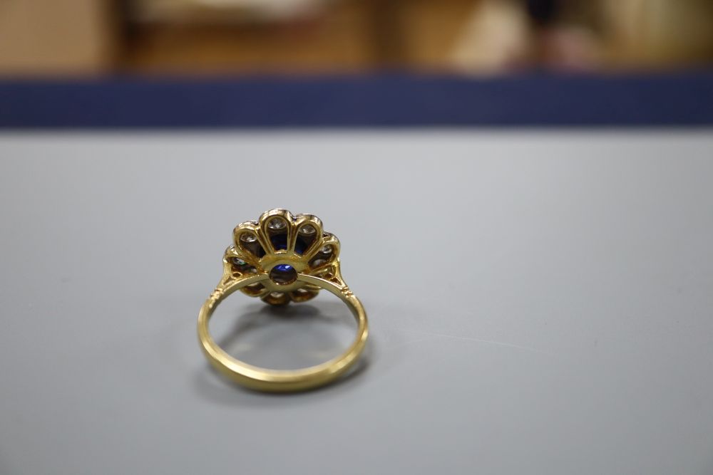 A modern 18ct gold, synthetic sapphire? and diamond circular cluster ring, size P, gross 4.7 grams.